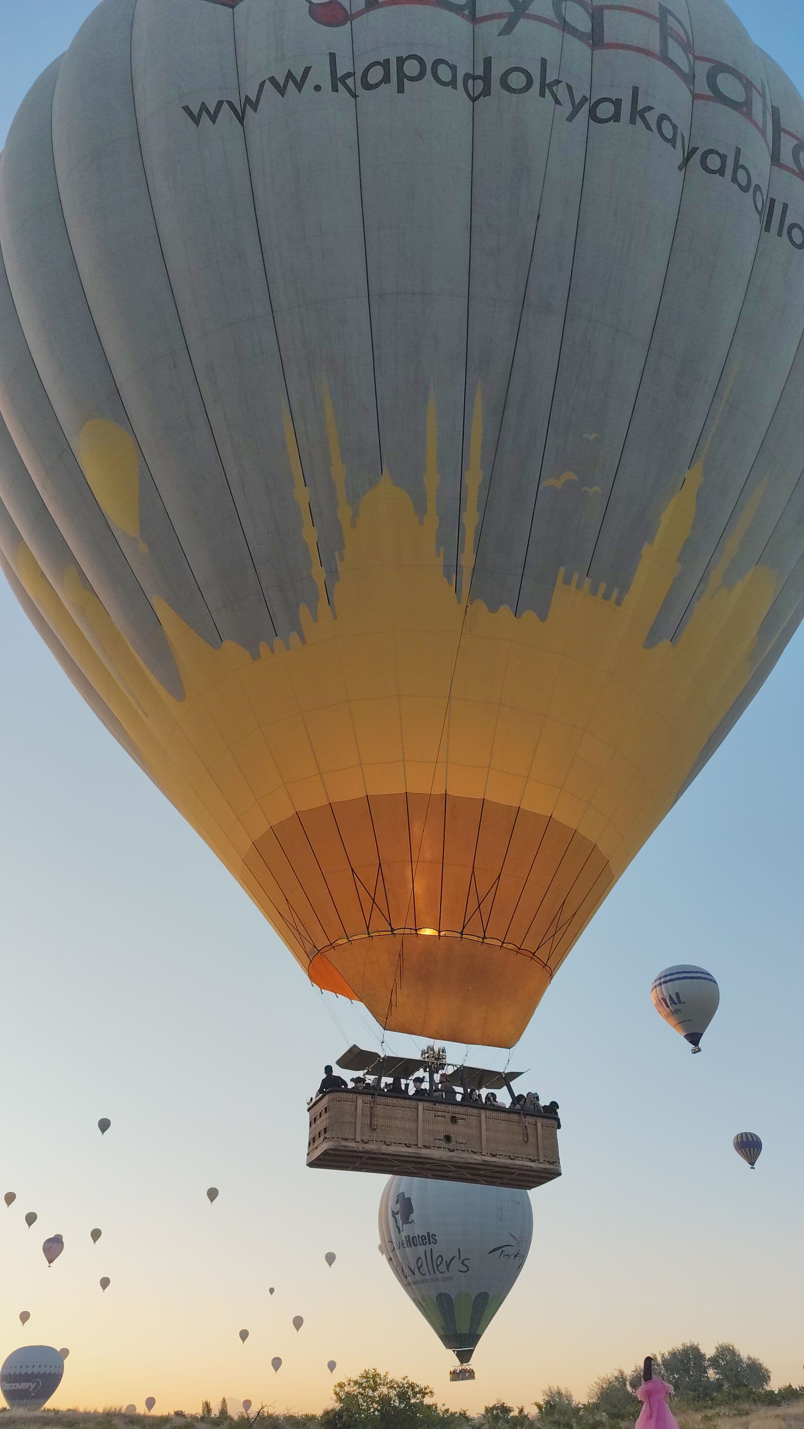 Dozens of balloons rising over Cappadocia at sunrise